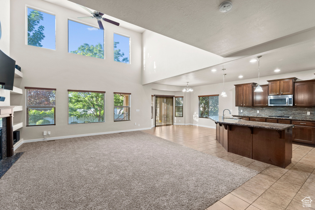 Kitchen with light tile patterned flooring, hanging light fixtures, and plenty of natural light