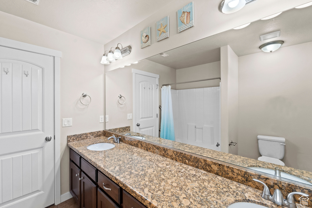 Bathroom featuring toilet and double vanity