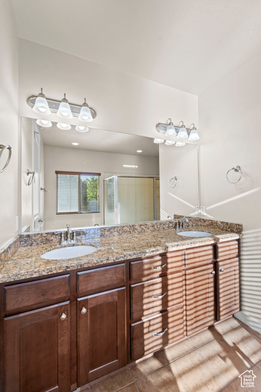 Bathroom featuring tile patterned flooring and double sink vanity