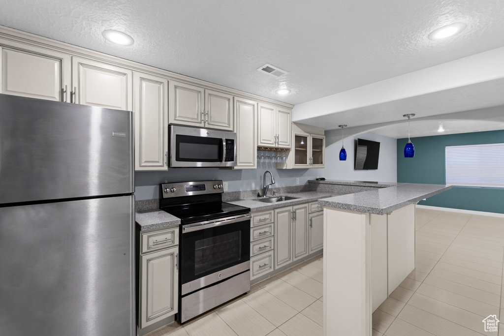 Kitchen featuring sink, light tile patterned flooring, and stainless steel appliances