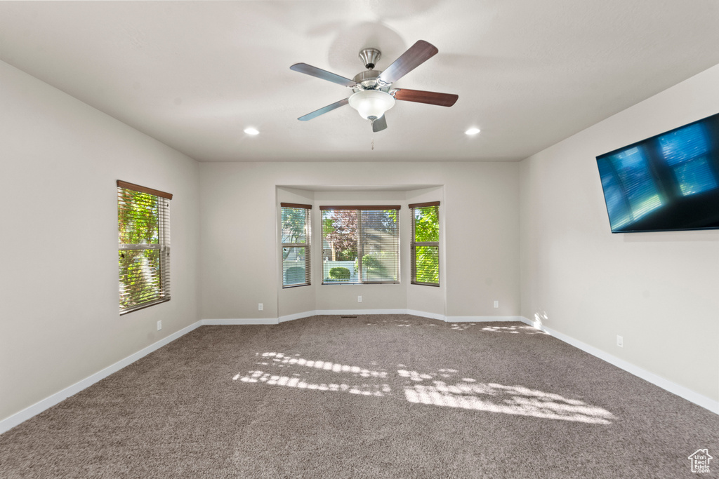 Unfurnished room featuring carpet flooring and ceiling fan