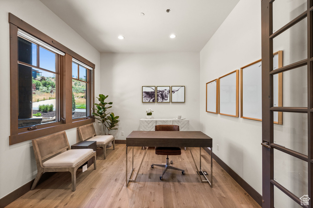 Office space with light hardwood / wood-style flooring