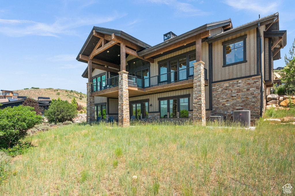 Back of property featuring a balcony and central AC