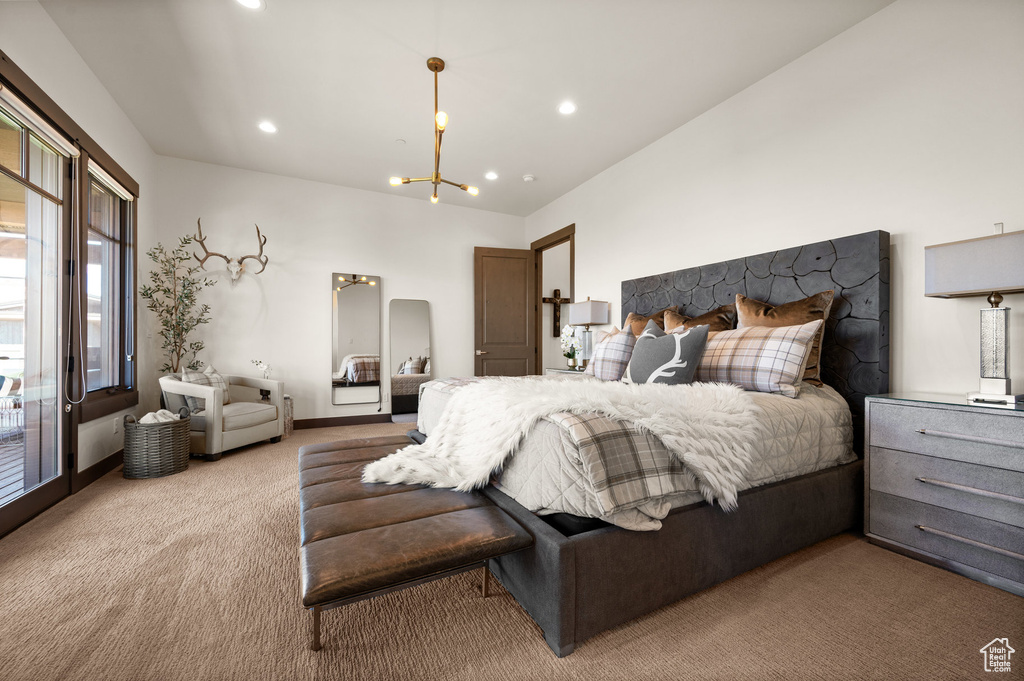 Carpeted bedroom featuring an inviting chandelier