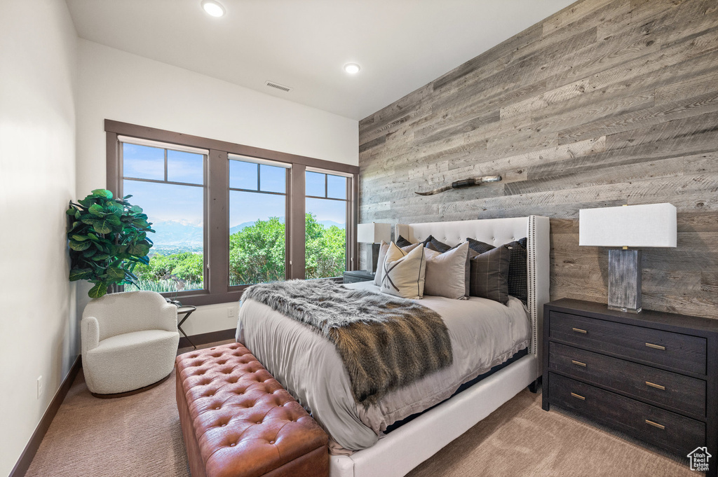 Carpeted bedroom featuring wooden walls