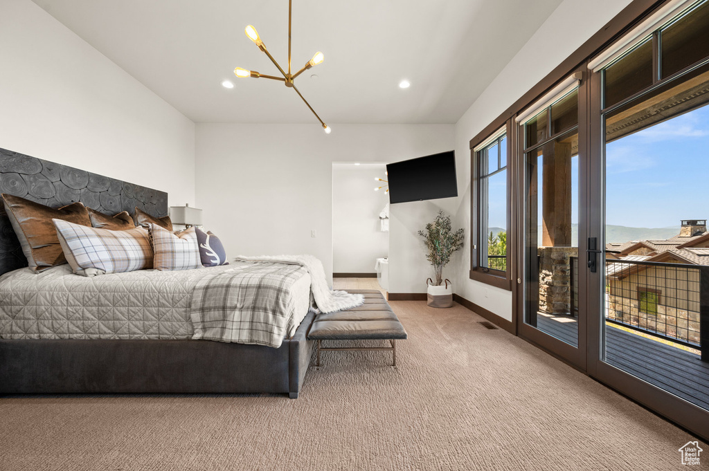 Carpeted bedroom featuring a chandelier and access to outside