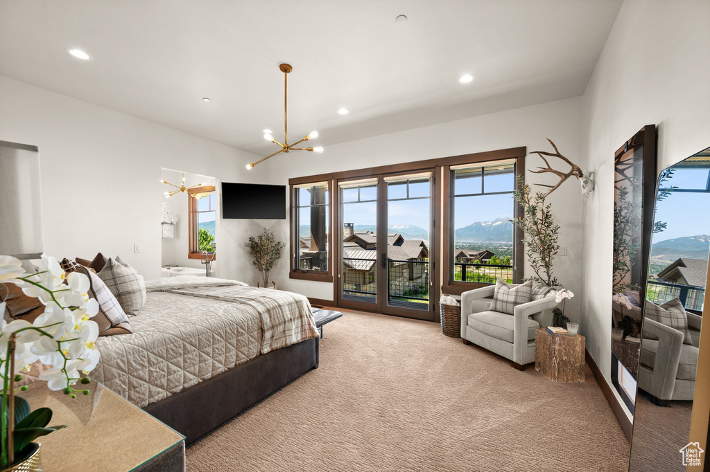 Carpeted bedroom featuring an inviting chandelier and access to exterior