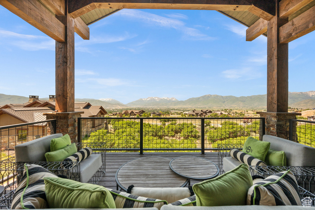 Wooden terrace featuring a mountain view and an outdoor living space