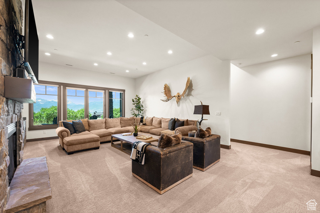 Carpeted living room with a stone fireplace