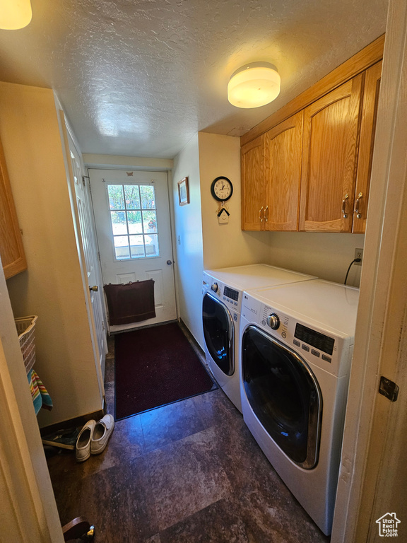 Laundry room with cabinets, a textured ceiling, washer and dryer, and tile patterned floors