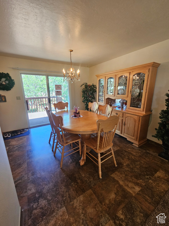 Tiled dining room with a textured ceiling and a chandelier