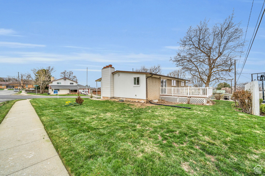 Exterior space featuring a yard and a wooden deck