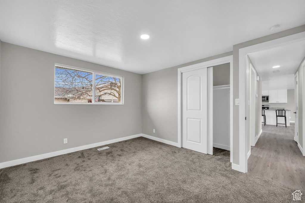 Unfurnished bedroom featuring a closet and light hardwood / wood-style floors