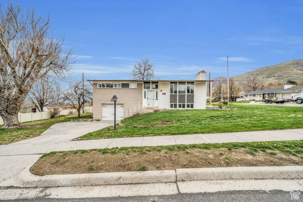 View of front of property with a front lawn and a mountain view