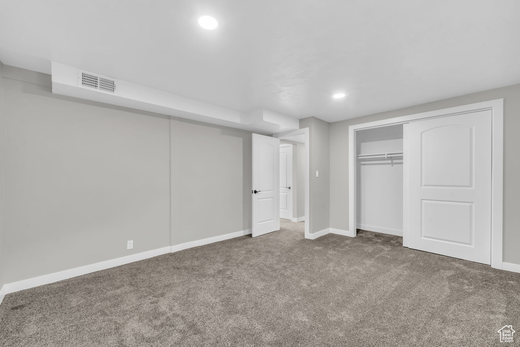 Unfurnished bedroom with dark carpet and a closet