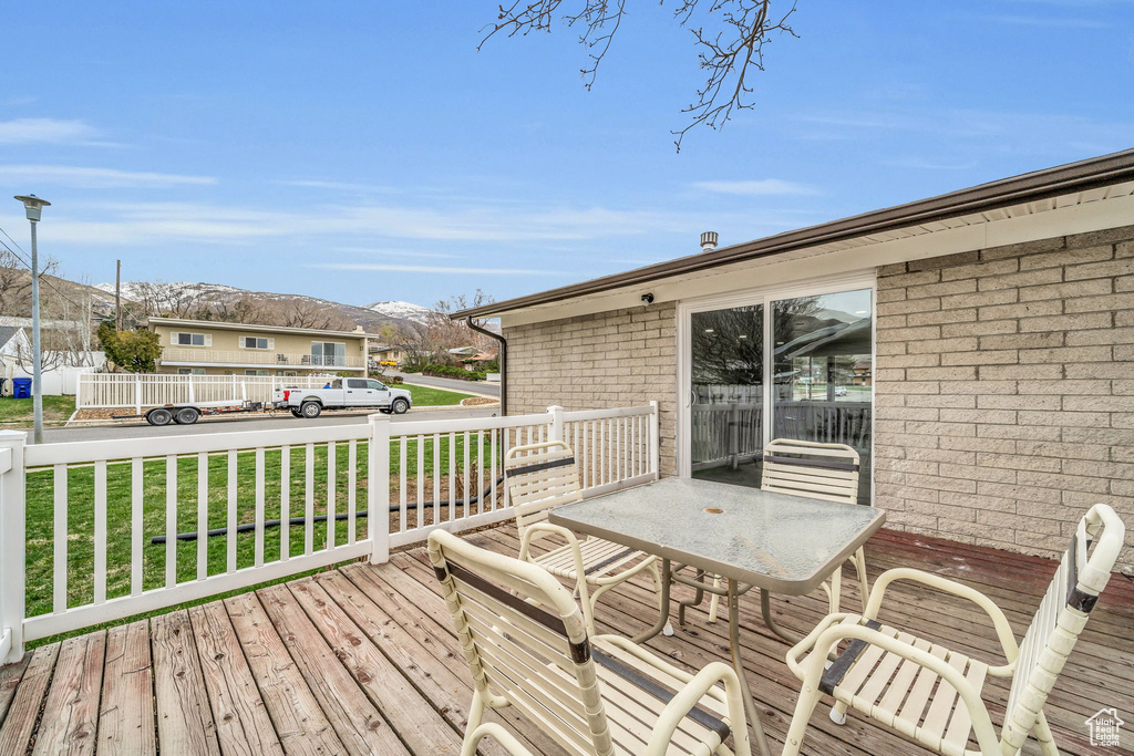 Wooden terrace with a mountain view and a yard