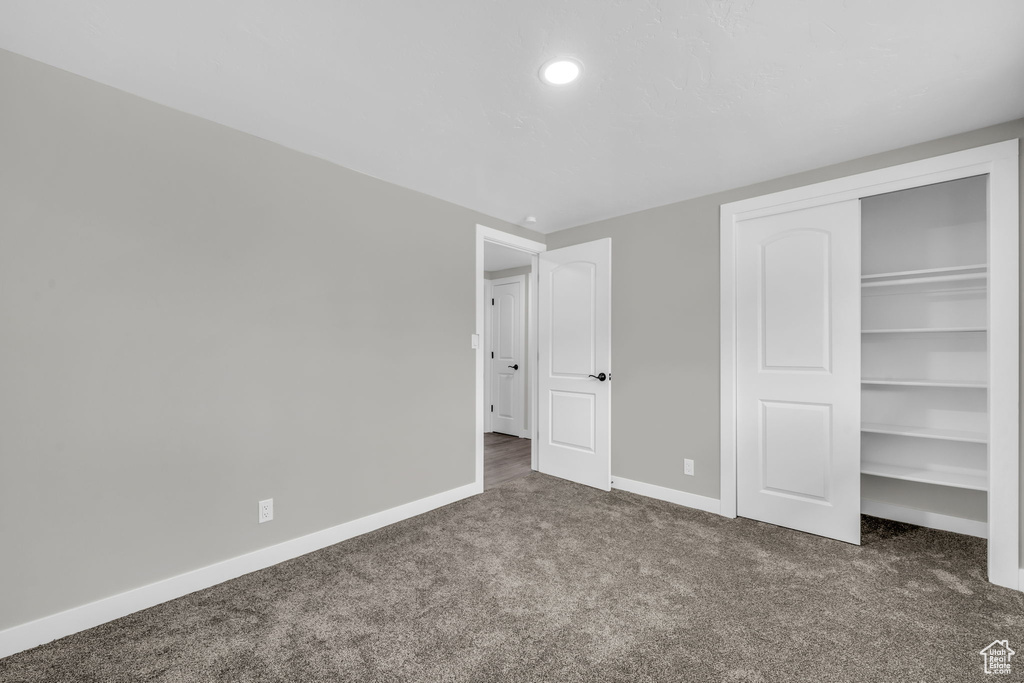 Unfurnished bedroom with dark carpet