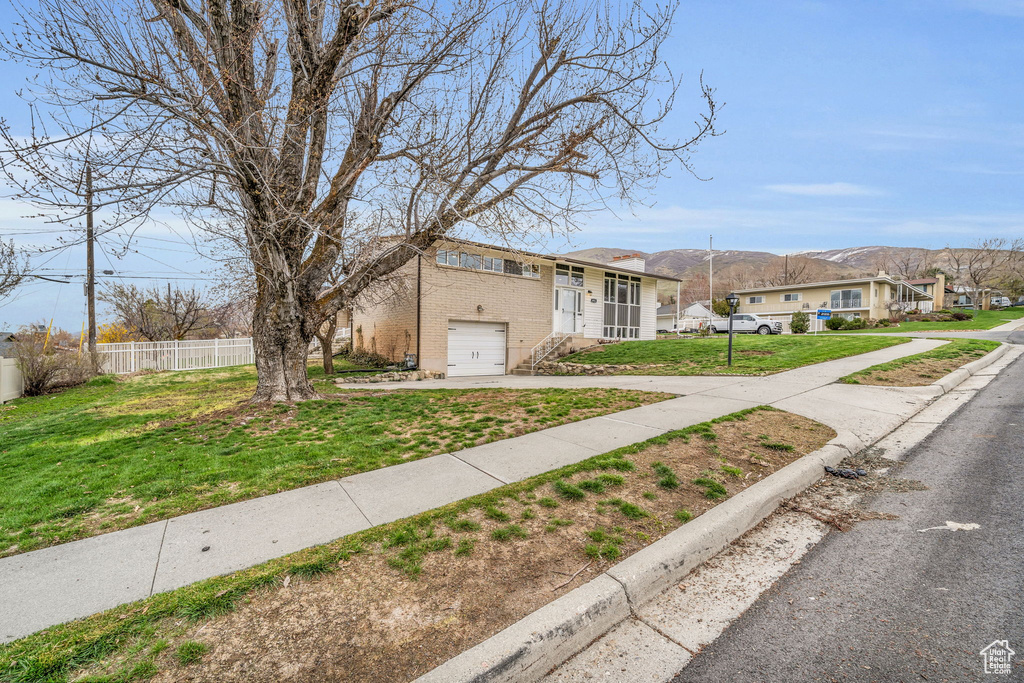 View of front of property featuring a garage and a front lawn