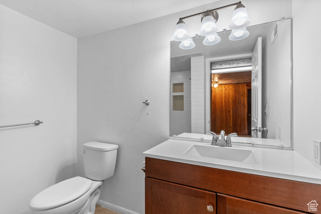 Bathroom with vanity, a chandelier, and toilet