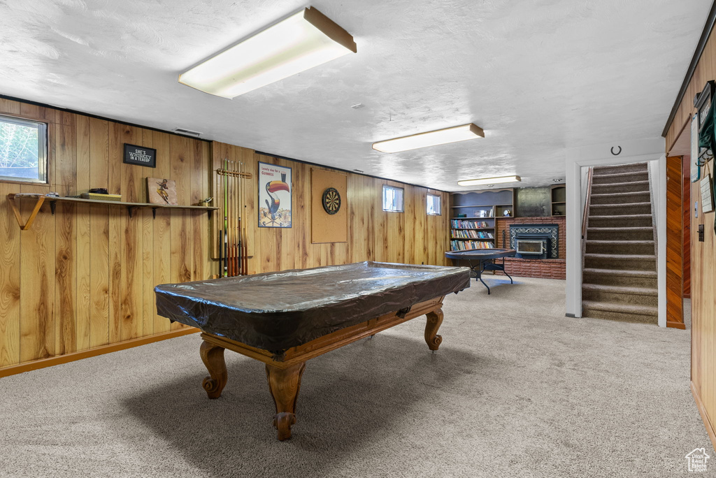 Rec room with pool table, carpet floors, a fireplace, and wooden walls