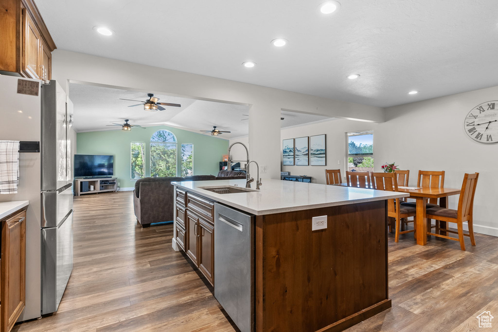 Kitchen with ceiling fan, a center island with sink, hardwood / wood-style flooring, and a wealth of natural light