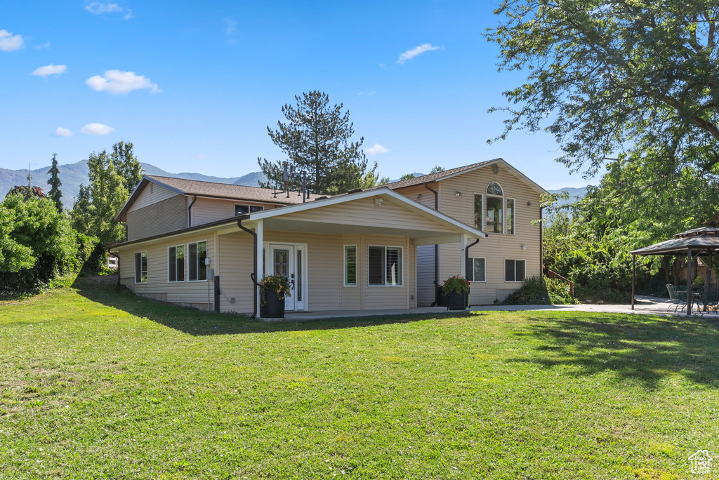 Back of property featuring a lawn