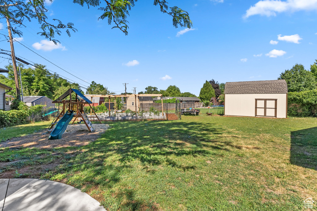 View of yard with a storage unit and a playground