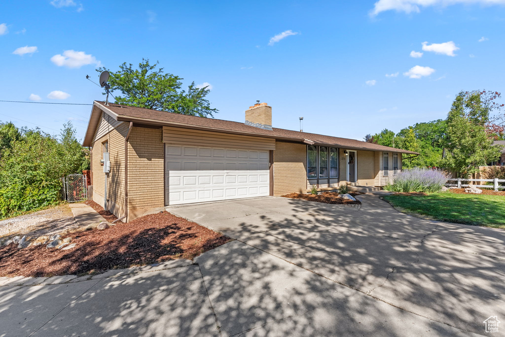 Single story home featuring a garage and a front lawn