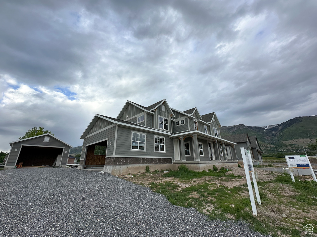 Craftsman-style house with board and batten siding, an outbuilding, and a mountain view