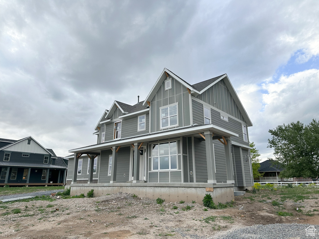 View of front of home with board and batten siding and covered porch