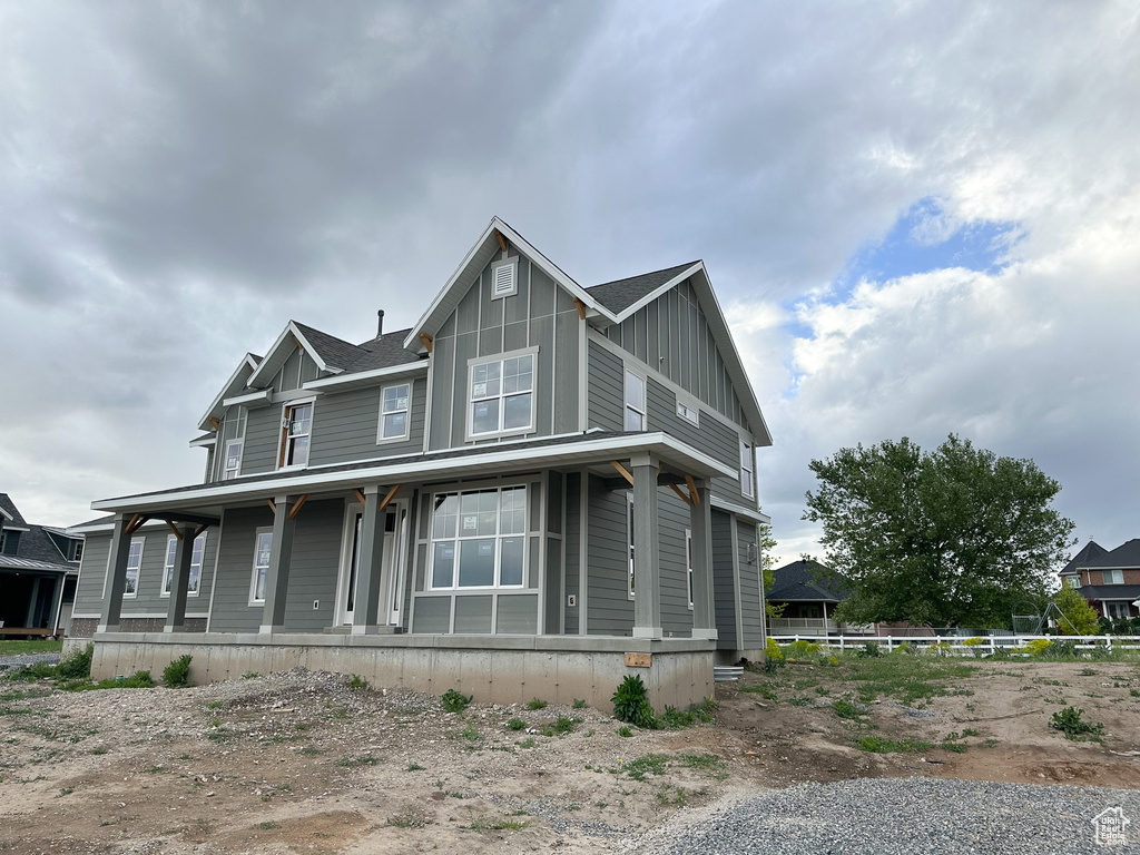 View of front facade featuring board and batten siding and covered porch