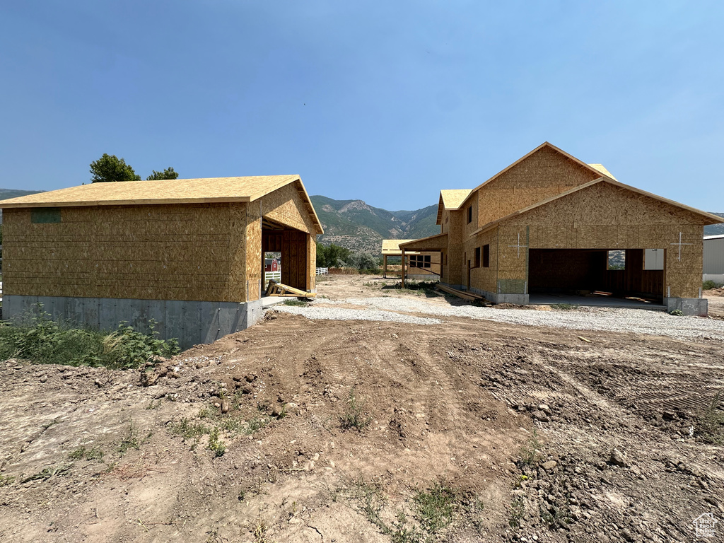 View of side of home with a mountain view, a carport, and a garage