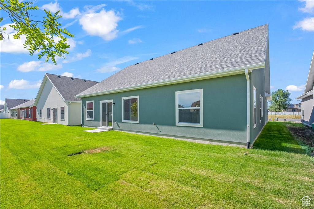 Rear view of house featuring a lawn