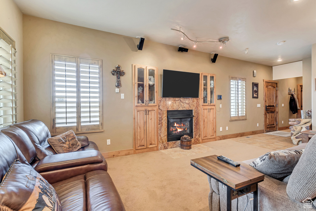 Carpeted living room with a fireplace and rail lighting