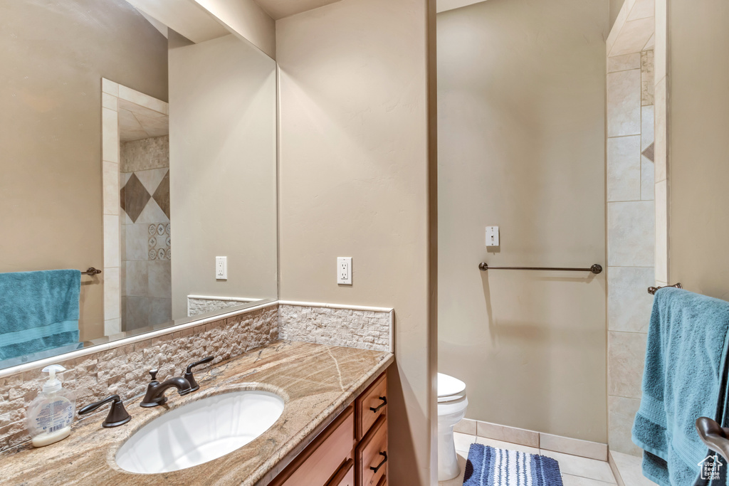 Bathroom featuring vanity, tile patterned flooring, and toilet