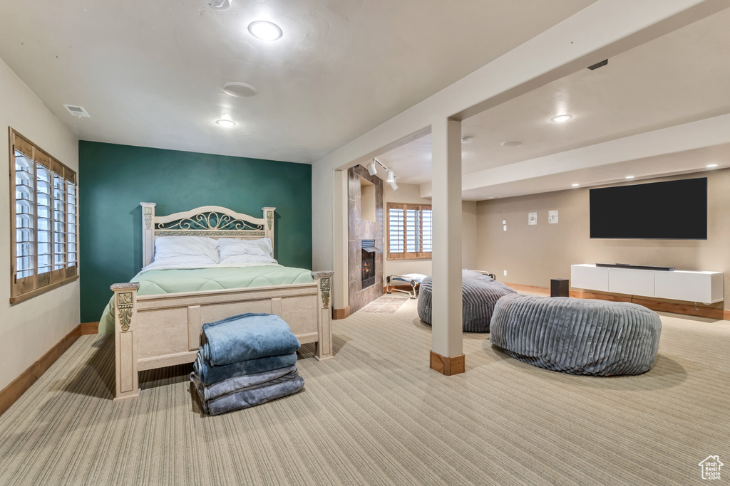 Carpeted bedroom featuring a tiled fireplace