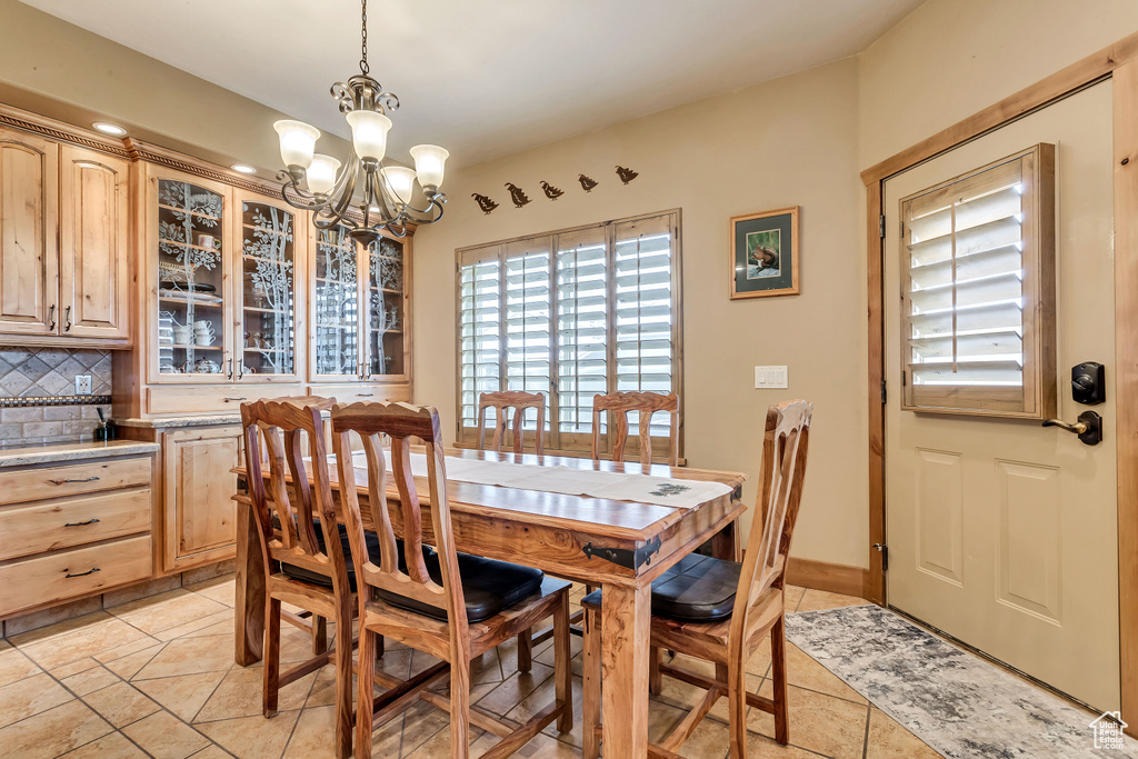 Dining space with an inviting chandelier and light tile patterned floors