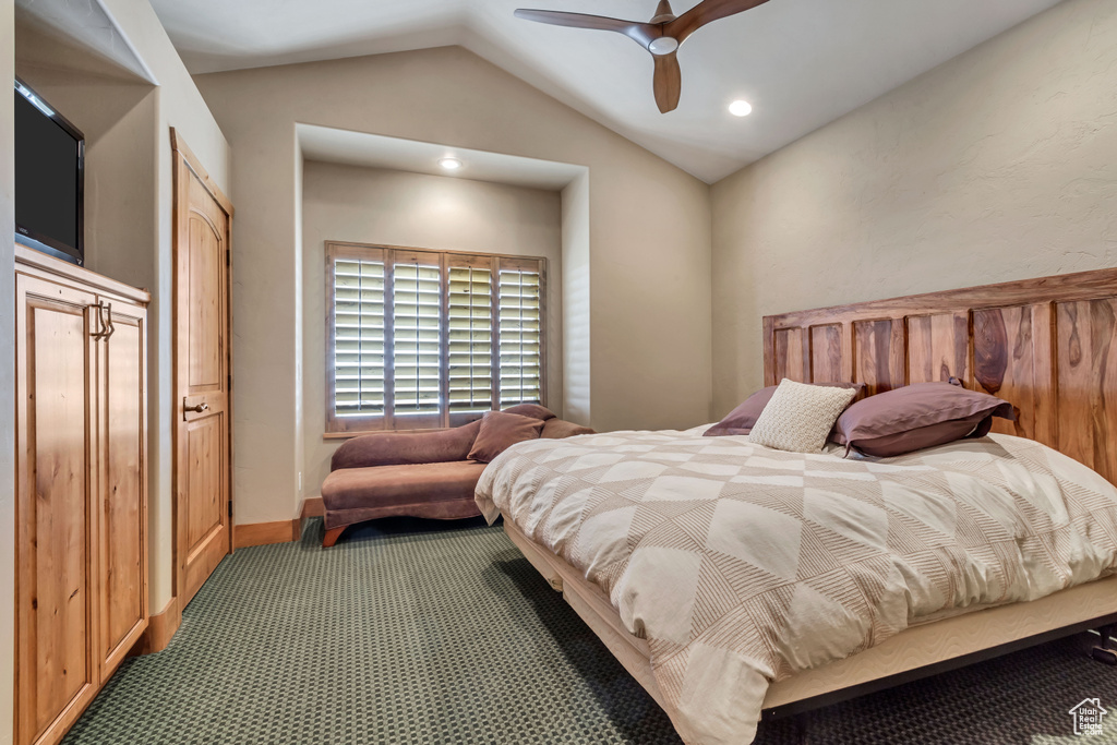 Bedroom with lofted ceiling, dark carpet, and ceiling fan