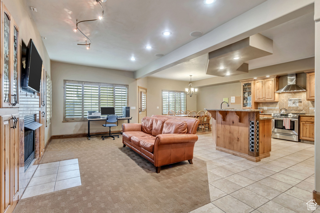 Tiled living room with a chandelier, track lighting, and sink