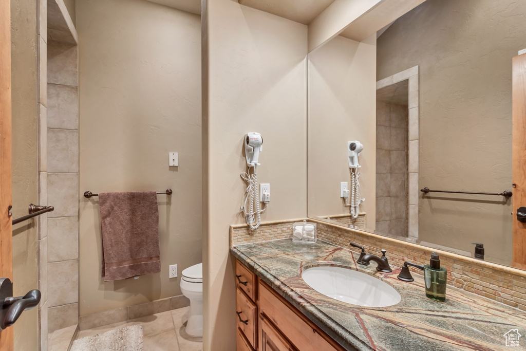 Bathroom with tile patterned floors, toilet, and vanity