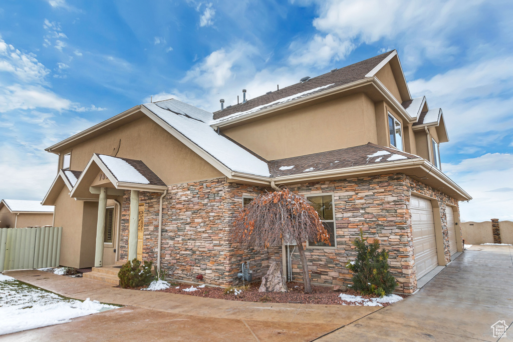 View of front of property featuring a garage and solar panels