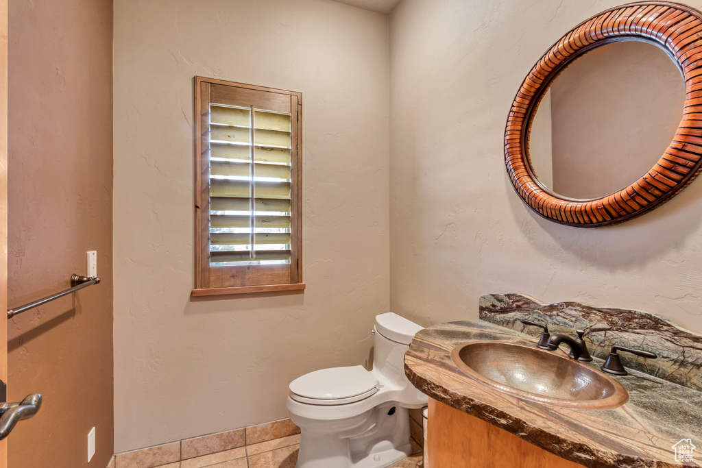 Bathroom with vanity, tile patterned floors, and toilet