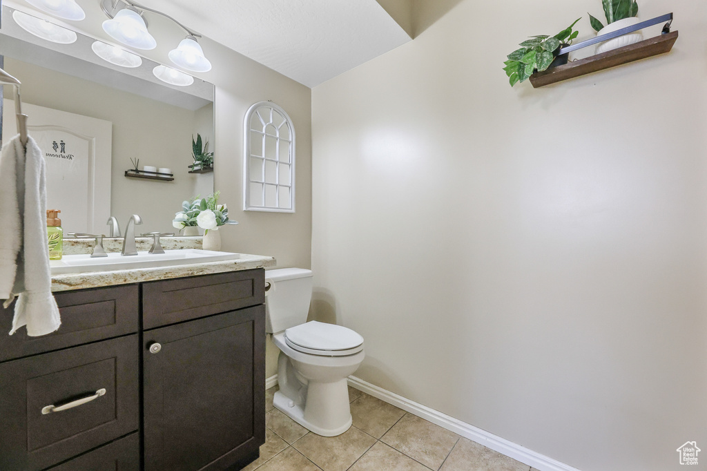 Bathroom featuring vanity, toilet, and tile patterned flooring