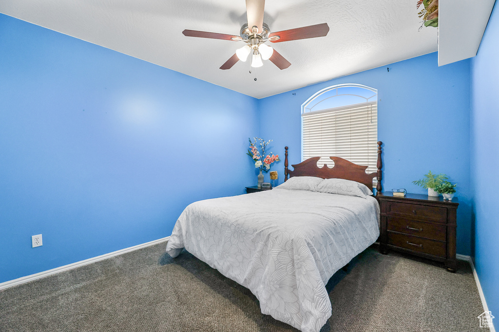 Carpeted bedroom featuring ceiling fan