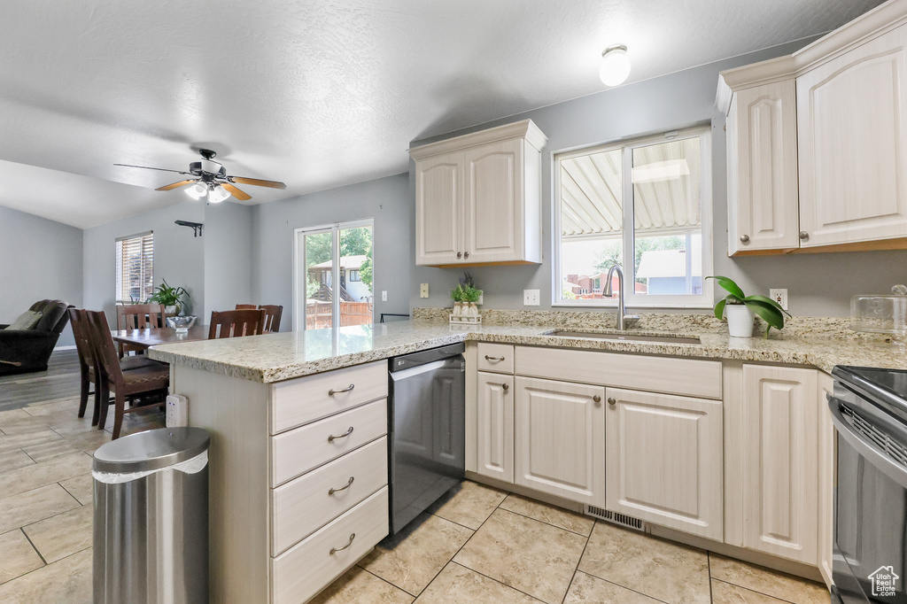 Kitchen featuring stainless steel appliances, sink, kitchen peninsula, light tile patterned flooring, and ceiling fan