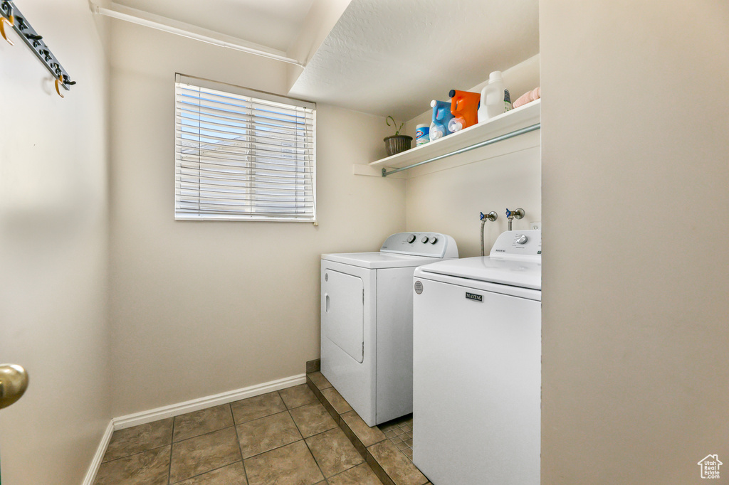 Laundry area with tile patterned floors and washing machine and clothes dryer