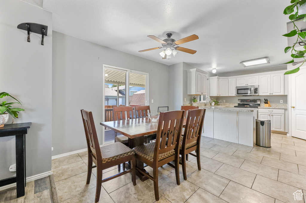 Dining area featuring ceiling fan and light tile patterned floors