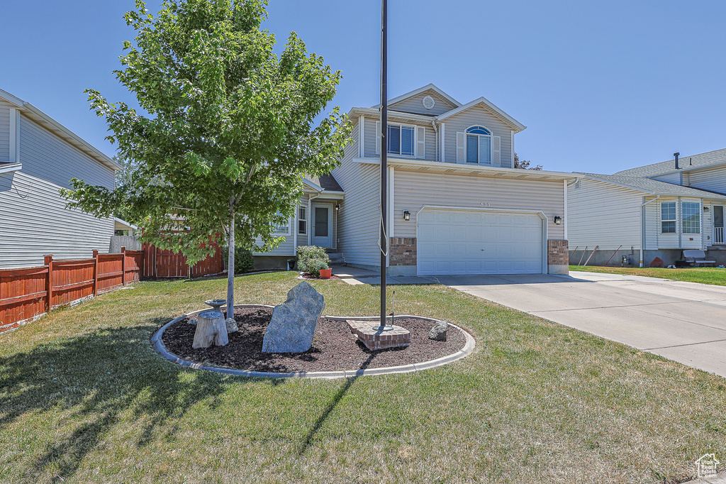 View of front of property featuring a garage and a front yard