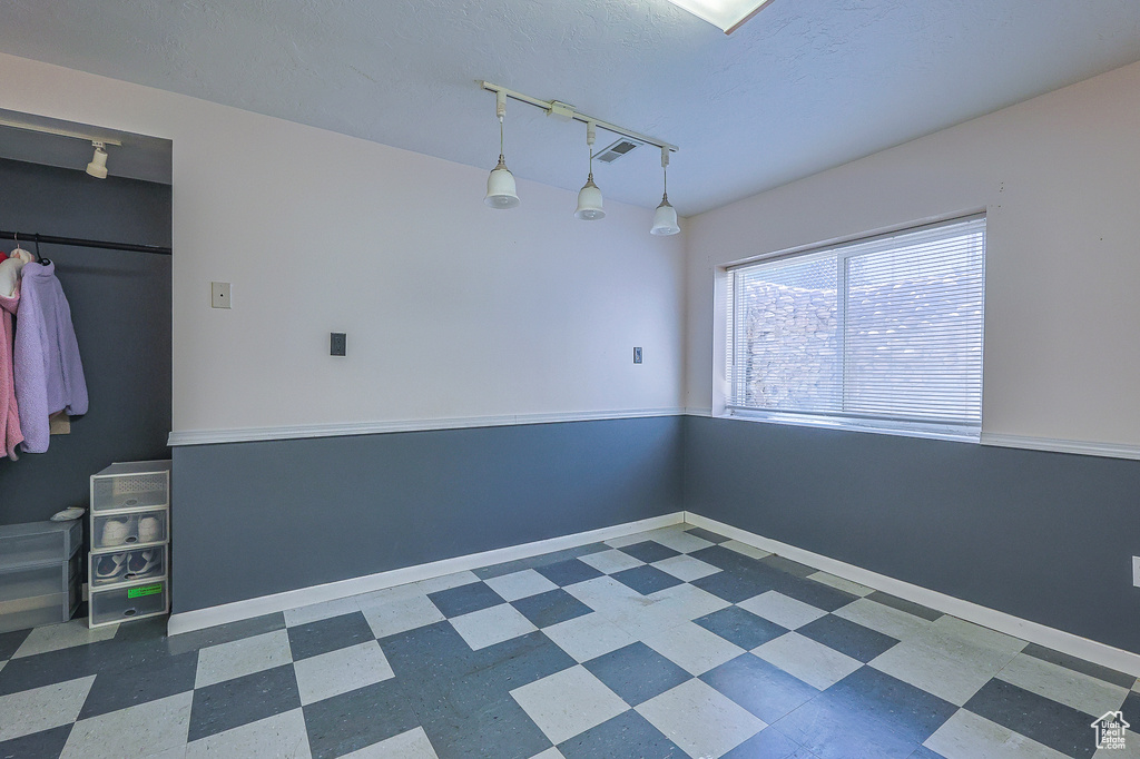 Interior space featuring rail lighting and dark tile patterned flooring