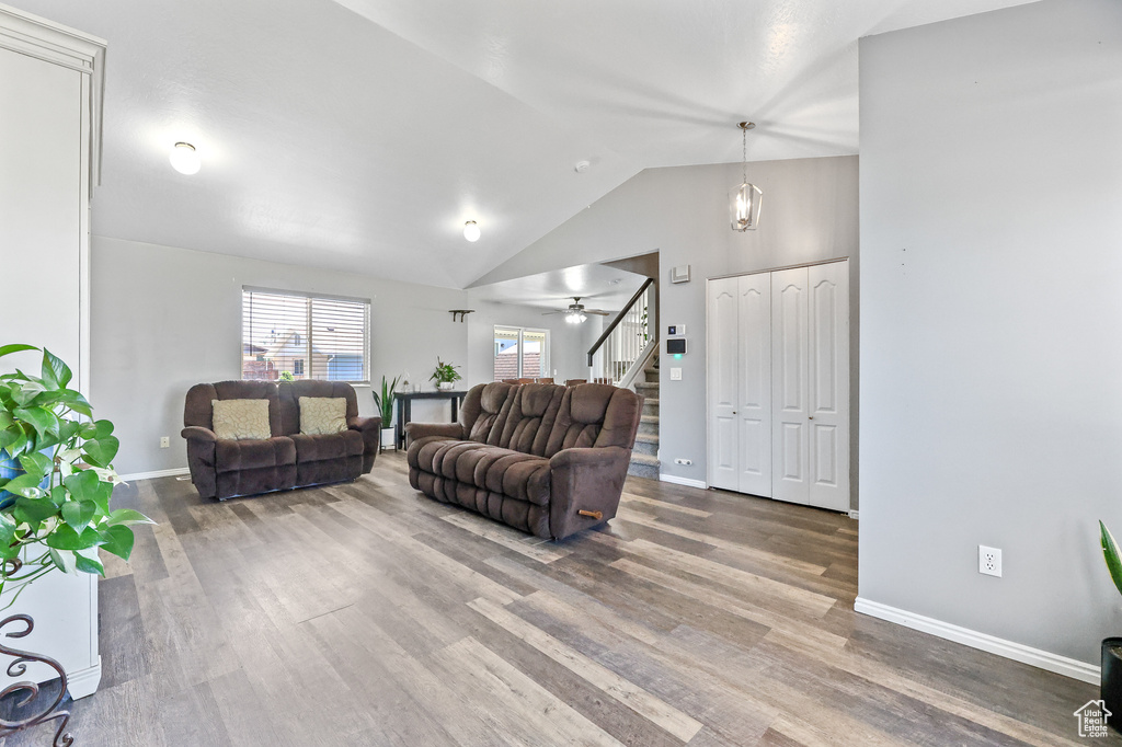 Living room with high vaulted ceiling, dark hardwood / wood-style floors, and ceiling fan